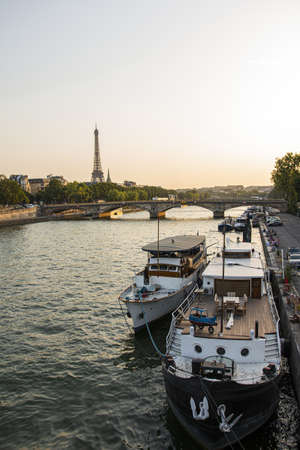A high angle shot of a docked yacht on the river with Eiffel tower background in Parisの写真素材