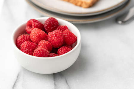 The fresh raspberries on the table for breakfast