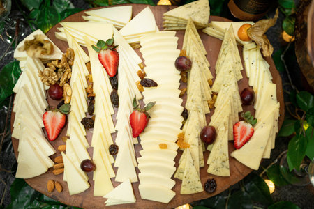 A top view of a cheese platter with fruits on a table