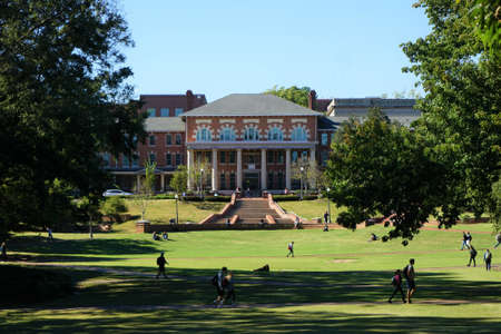 A sunny day on a college campus with students walking across the campus