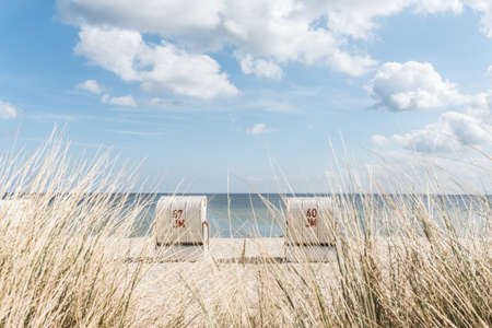 Two baltic sea beach chairs at famous holiday an camping area Scharbeutz having clear blue sky with white clouds.の写真素材