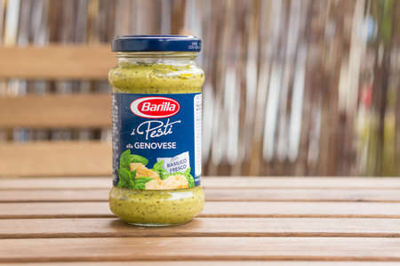 POZNAN, POLAND - Jun 28, 2016: Barilla green pesto in a glass jar on a tableの写真素材