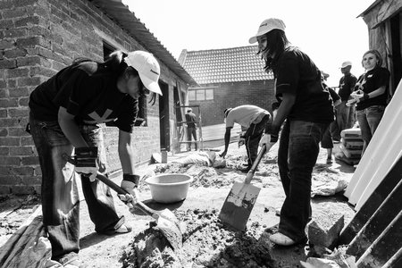 JOHANNESBURG, SOUTH AFRICA - Jan 06, 2021: Soweto, South Africa - September 05, 2009: Diverse Community Outreach program mixing cement for building a small affordable houseのeditorial素材
