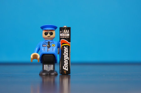 POZNAN, POLAND - Dec 28, 2017: Playtive police man figurine standing next to a Energizer AAA Alkaline batteのeditorial素材
