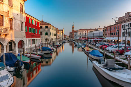 CHIOGGIA, ITALY - Jun 20, 2020: The main canal of the city of Chioggia called Little Venice with its boats reflecting the adjacent buildings and shops on the surfaceのeditorial素材