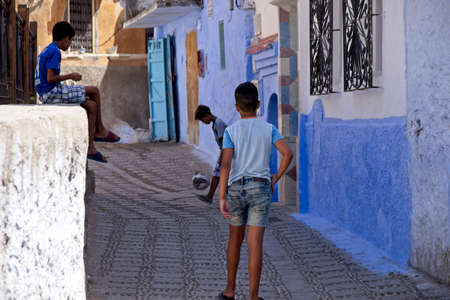 CHEFCHAOUEN, MOROCCO - Sep 17, 2018: Three boys playing football on the streets of the blue city named as Chaouenのeditorial素材