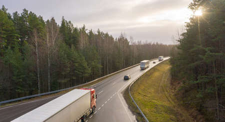 An aerial view on the Via Baltica highway with driving vehicles crossing the pine forest dunes in Luitemaa nature reserveのeditorial素材