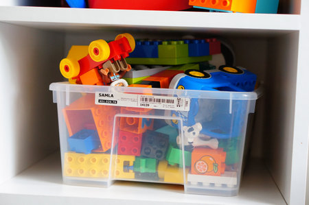 POZNAN, POLAND - Jul 09, 2017: Plastic container with colorful Lego Duplo bricks on a wooden shelfのeditorial素材