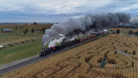 A high angle shot of an old train with smoke coming out of is chimney