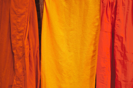 A closeup shot of Buddhist monks orange and yellow robes hung up to dry in the sunの写真素材