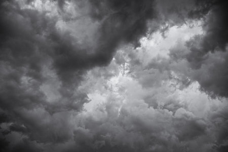 A low angle greyscale of a dark cloudy sky in the evening - perfect for backgrounds and wallpapers
