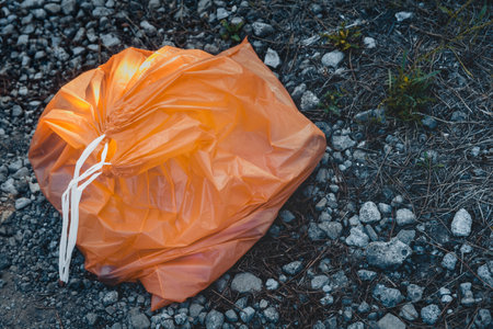 A high angle shot of a full garbage bag on the ground - environmental pollution conceptの写真素材