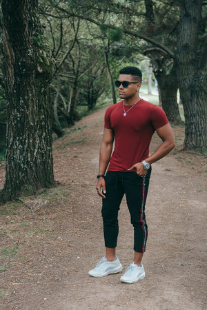 A beautiful shot of a young stylish man with sunglasses in the park