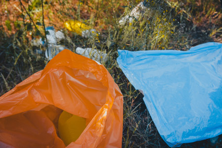 A high angle shot of plastic garbage bags on the ground - plastic pollution concept
