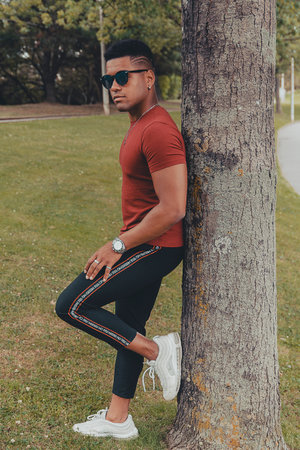 A beautiful shot of a young stylish man with sunglasses in the park