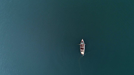 A high angle shot of a rowboat in the middle of a beautiful and calm ocean