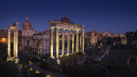 A beautiful shot of the roman forum under a dark blue sky at night time