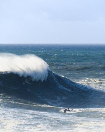 A vertical image of a surfer at the base of a big wave waiting for the right moment to surfの写真素材