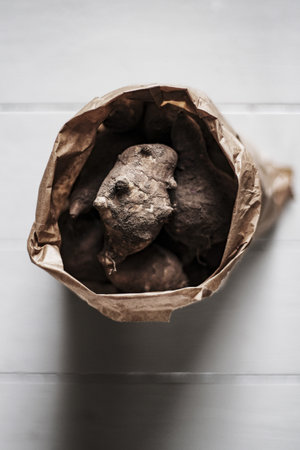 A top view of Jerusalem artichokes in a brown bag with a blurred backgroundの写真素材