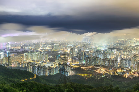 A beautiful shot of tall city buildings under a cloudy sky at nightの写真素材