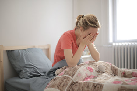 A shallow focus shot of a crying female who is lying in bedの写真素材