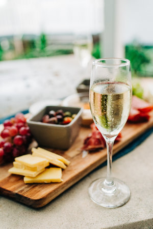 A selective focus shot of a glass of champaign by a tray of a delicious breakfastの写真素材