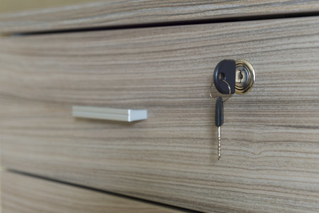A closeup selective focus shot of a nightstand drawer with a lockの写真素材