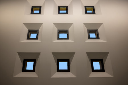 A closeup low angle shot of nine small windows isolated on white wall