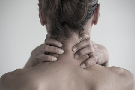 A closeup shot of a female having a neck painの写真素材