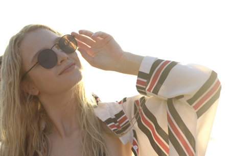 An attractive blonde female with sunglasses on the beach