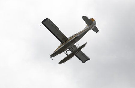 A low angle picture of a seaplane flying over the clear sky