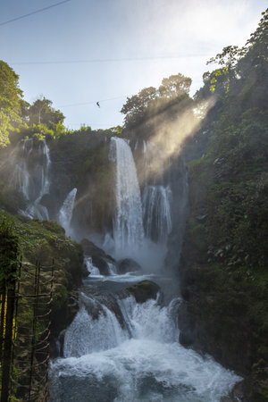 A vertical picture of a beautiful Pulhapanzak waterfall on Lake Yojoa under the clear sky in Hondurasの写真素材