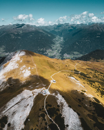A beautiful bird-eye vertical scenery of mountains and a lonesome house