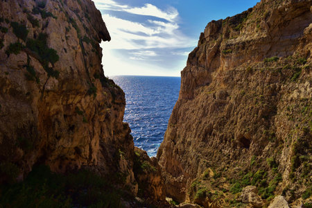 A beautiful shot of a v-shaped valley in Migra il-Ferha Valley, Maltese Islands, Malta on a sunny dayの写真素材