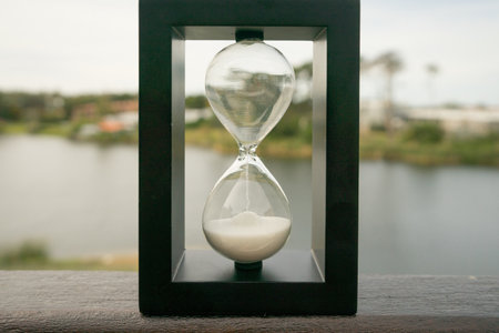 A beautiful shot of a classic vintage Hourglass or Sandglass Clock with nature in the background