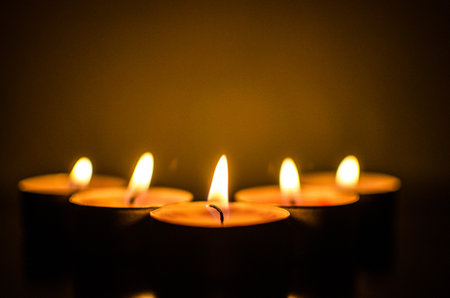 A closeup shot of burning candles on a blurred backgroundの写真素材