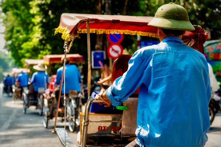 A beautiful shot of a male riding his rickshaw taken from behindの写真素材