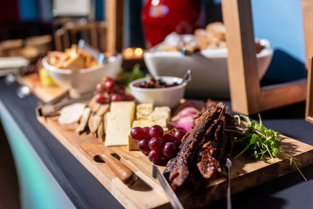 A closeup shot of steak with cheese and grapes on a corporate event