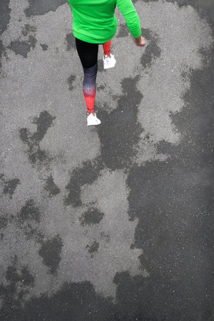 A beautiful shot of a young male running on an asphalt road