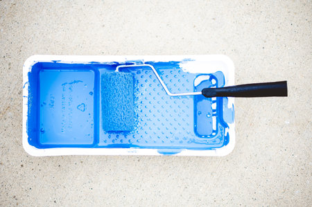 A high angle shot of blue paint in a paint container with a brush - concept: painting
