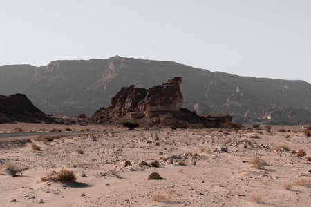 A beautiful view of the big rocks in the middle of a desert surrounded by mountains