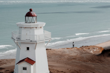 A high angle shot of a beautiful lighthouse on the beach overlooking the ocean