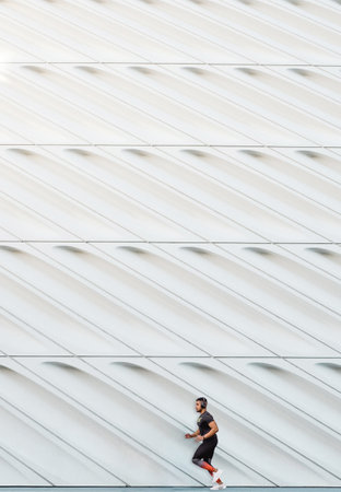 A beautiful shot of a young male doing exercise on a white wall backgroundの写真素材