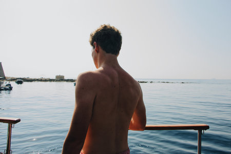 An athletic male standing at the sea on a sunny day