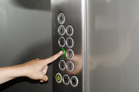 A closeup shot of a person's hand pressing elevator buttons