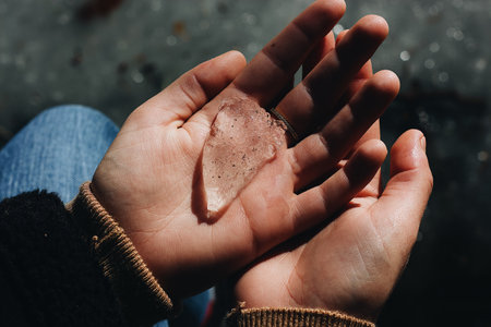 A high angle shot of a person holding a piece of crystal rock
