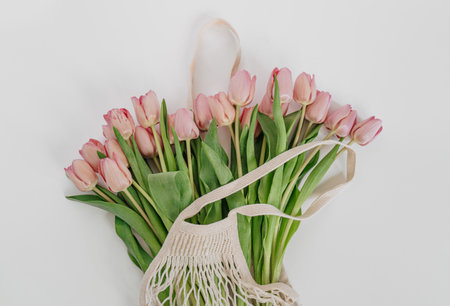 A closeup shot of the bouquet of pink tulips in an eco net string bagの写真素材