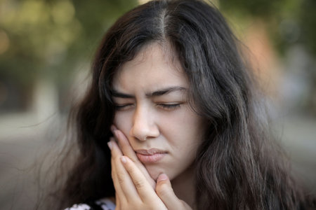 A young female with long dark hair having a terrible toothacheの写真素材