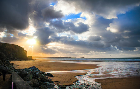 A beautiful shot of a sandy beach with rocks under sunlight