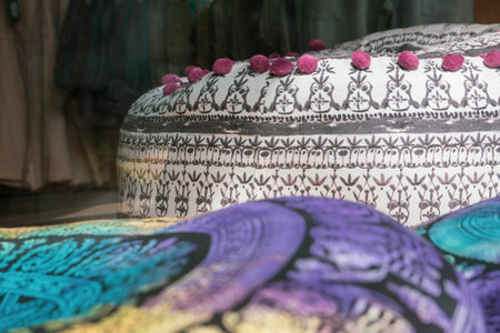 A closeup shot of colorful cushions on the floor with curtains on the backgroundの写真素材